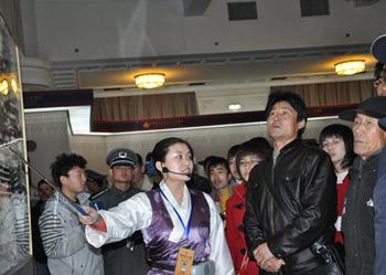 A guide introduces photos at an exhibition marking the 50th anniversary of the Democratic Reform in Tibet Autonomous Region in Beijing, Feb. 25, 2009.(Xinhuanet Photo)