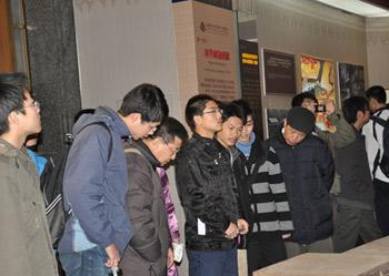 Visitors look at pieces at an exhibition marking the 50th anniversary of the Democratic Reform in Tibet Autonomous Region in Beijing, Feb. 25, 2009.(Xinhuanet Photo)