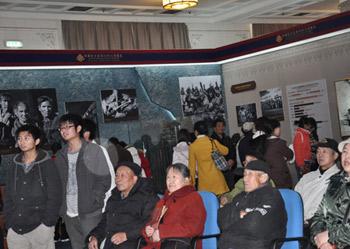 Visitors watch a documentary showing the past and present of Tibet at an exhibition marking the 50th anniversary of the Democratic Reform in Tibet Autonomous Region in Beijing, Feb. 25, 2009. (Xinhuanet Photo)