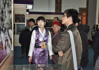 A guide introduces a photo at an exhibition marking the 50th anniversary of the Democratic Reform in Tibet Autonomous Region in Beijing, Feb. 25, 2009.(Xinhuanet Photo)
