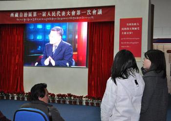 Visitors watch a documentary at an exhibition marking the 50th anniversary of the Democratic Reform in Tibet Autonomous Region in Beijing, Feb. 25, 2009. (Xinhuanet Photo)
