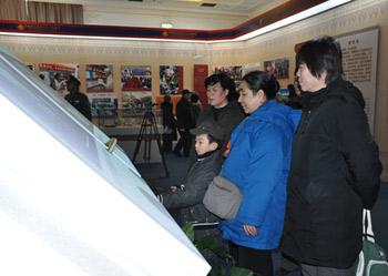 Visitors read an electronic book on the history of Tibet at an exhibition marking the 50th anniversary of the Democratic Reform in Tibet Autonomous Region in Beijing, Feb. 25, 2009.(Xinhuanet Photo)