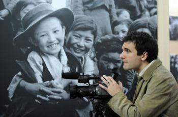 Sergi Vicente, a Spanish TV correspondent, works at the "50th Anniversary of Democratic Reforms in Tibet" Exhibition in Beijing, capital of China, March 18, 2009. A number of foreign journalists, organized by the Information Department of China's Foreign Ministry, visited the exhibition on Wednesday. (Xinhua/Xie Huanchi) 