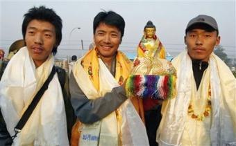 Nepalese Sherpa brothers, from right, Nima Gyalzen, Pemba Dorje, and Phurba Tenzing pose with the statue of Lord Buddha before leaving Katmandu, Nepal, Sunday, April 12, 2009. The brothers hoping to set a new record by spending 24 hours at the top of the world set out Sunday for the summit of Mount Everest.(AP Photo/Binod Joshi)