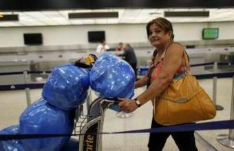 Aracely Blanco, a Cuban-American, leaves the counter of flights to Cuba at the Miami International Airport, Florida April 13, 2009.U.S. President Barack Obama has directed officials to look at the possibility of starting regularly scheduled commercial flights between the United States and Cuba, the White House said on Monday.REUTERS/Carlos Barria