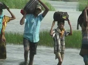 Sri Lankan civilians carrying there belongings stream out of the last sliver of land held by the rebels in the Mullattivu Region of Sri Lanka in the image taken from TV Monday April 20, 2009. (AP Photos/Derana TV. Via AP Television)