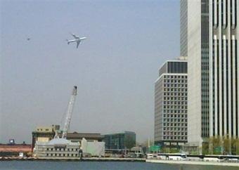 In this image taken with a cell phone by Jason McLane, the primary presidential aircraft, a Boeing 747 known as Air Force One when the president is aboard, flies low over New York Harbor, followed by an F-16 chase plane during a federal government photo op Monday, April 27, 2009. A low-flying Boeing 747 escorted by two fighter jets as part of a federal government photo opportunity over lower Manhattan caused a brief panic among workers near ground zero on Monday.(AP Photo/Jason McLane)