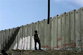 A hose from a machine used to pump cement is lowered to a Palestinian worker at a construction site next to Israel's separation barrier in the Aida refugee camp near the West Bank town of Bethlehem, Monday, April 27, 2009.  (AP Photo/Tara Todras-Whitehill) 
