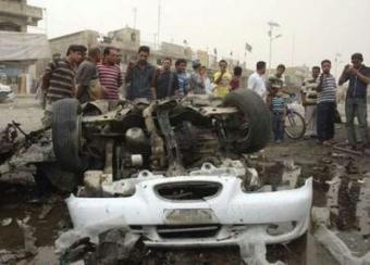 Residents gather at a burnt vehicle at the site of a bomb attack in Baghdad's Sadr City April 29, 2009. The toll from twin car bomb blasts on Wednesday in a busy market in Baghdad jumped to 41 killed and 68 wounded, Iraqi police said.REUTERS/Kahtan al-Mesiary