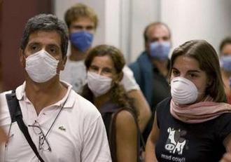 Argentine tourists wear surgical masks inside the airport in Mexico City May 3, 2009. REUTERS/Jorge Dan