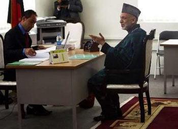 Afghan President Hamid Karzai gestures while being registered to stand for re-election in Kabul May 4, 2009. Karzai officially registered on Monday to stand for re-election, and named current vice-president Karim Khalili and former vice-president Mohammad Qasim Fahim as his two running mates.REUTERS/Ahmad Masood
