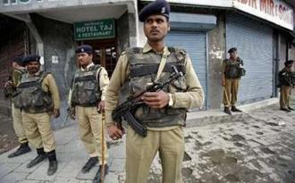 Indian police personnel stand guard at a security barricade during a strike in Srinagar May 6, 2009. REUTERS/Fayaz Kabli