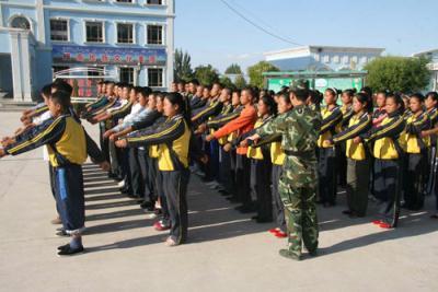 An army instructor trains children in a Xibe ethnic minority school in Yili prefecture, Xinjiang region, as taken on Saturday 23 August, 2009. [Photo:CRIENGLISH.com]