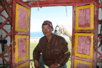 A nomad crouches at the gate of a tent in Xinjiang region, northwest China, Sunday August 24, 2009. [Photo:CRIENGLISH.com] 