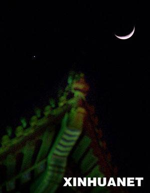 A crescent moon (R) is seen with the planet Venus in the sky over Beijing,Jan. 30, 2009. Venus and the moon appear close together, presenting a romantic scene for people during the Chinese Lunar New Year. This phenomenon will last 3 days from Jan.30, 2009, astronomer said.(Xinhua/Zhang Yanhui)