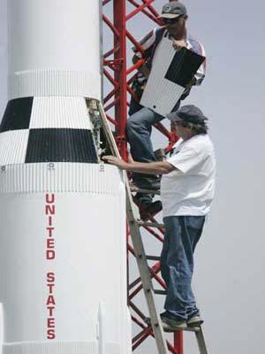 Tom Erb (top) and rocket builder Steve Eves get ready to install the hatch over the electronic control panel on Eves' one-tenth scale Saturn V rocket prior to a successful launch in Price, Maryland April 25, 2009. (Xinhua/Reuters Photo)