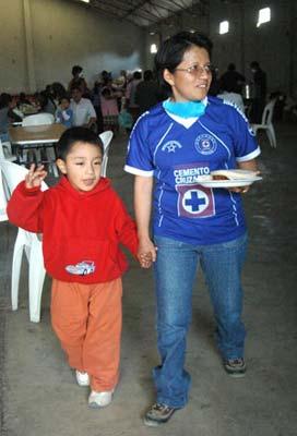 Four-year-old Edgar Hernandez (L), who has recovered from the A/H1N1 flu influenza recently, walks outside a free dining room with his mother at his hometown in Veracruz state in Mexico May 2, 2009. Hernandez is the first patient who was infected by the A/H1N1 flu influenza in Mexico. (Xinhua Photo)