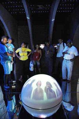 Visitors listen to the radio guide beside a round screen displaying the development of telecommunications in the Museum of Telecommunications in Brazilian city of Rio de Janeiro, May 9, 2009. The museum of Telecommunications is located in a culture center building in Rio de Janeiro. The museum, transformed and decorated since 1999, provides audio, vedio and other multimedia to vividly introduce the development of telecommunications in Brazil. (Xinhua photo)