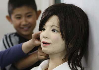 A humanoid robot named "Saya" (R) is touched by school pupils as she takes on a role as a school teacher during a demonstration at an elementary school in Tokyo May 7, 2009. The robot, developed by Tokyo University of Science professor Hiroshi Kobayashi, can speak different languages and make facial expressions like happiness, surprise, sadness, fear, anger or disgust with motors inside her face. (Xinhua/Reuters Photo)
