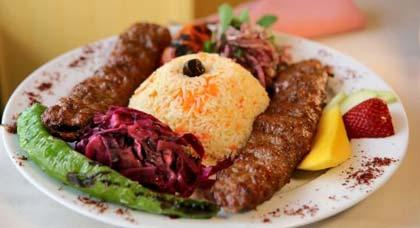 The&nbsp;adana&nbsp;kebab&nbsp;consists&nbsp;of&nbsp;two&nbsp;long&nbsp;rolls&nbsp;of&nbsp;ground&nbsp;lamb&nbsp;slipped&nbsp;off&nbsp;their&nbsp;skewers,&nbsp;white&nbsp;rice,&nbsp;and&nbsp;several&nbsp;vegetable&nbsp;sides.